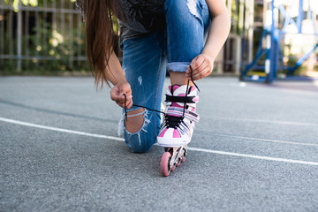 Urban scene of girl with putting on her roller skates.