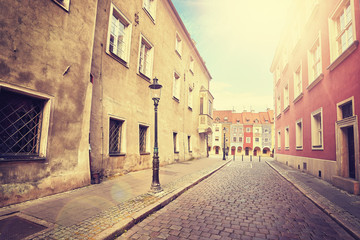 Vintage stylized street in Poznan old town with lens flare effect, Poland.