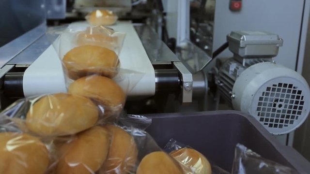 Bread for passengers of plane, packed on conveyor in transparent film.