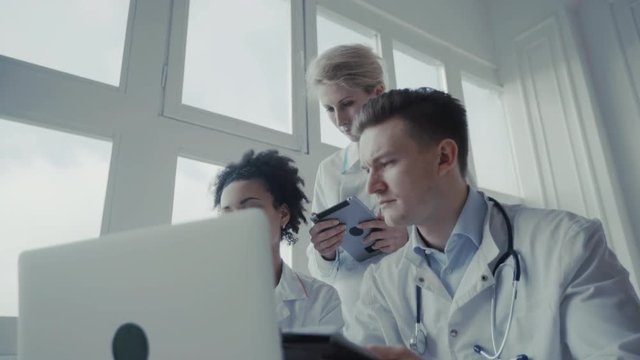 Healthcare, medical: Group of multi-ethnic doctors discuss and looking x-ray in a clinic or hospital. UHD 4K