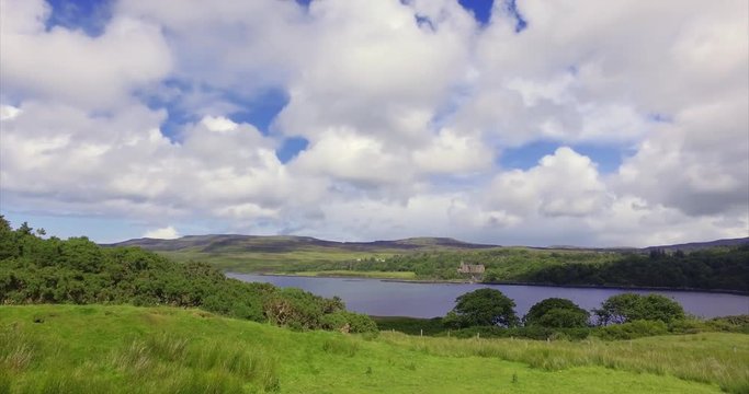Views of Dunvegan Castle from Uiginish, green summer meadows and the blue water of Loch Dunvegan