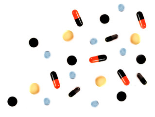 Different pills and capsules on white background.
