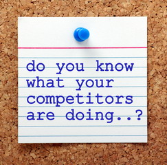 The question Do You Know What Your Competitors Are Doing in blue typescript on a paper note pinned...