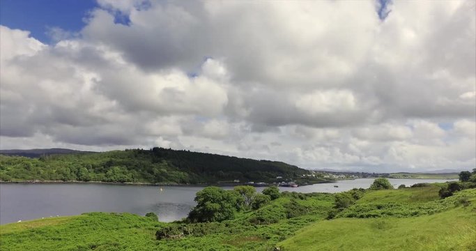 Views of Dunvegan town, panning around to Dunvegan Castle from the green meadows of Uiginish, with Loch Dunvegan in between