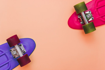 Pink and Purple Skateboards on peach-colored background. Flat lay fashion set.