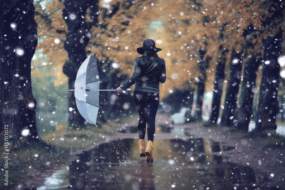 Wall mural autumn landscape city woman umbrella rain puddles of yellow trees