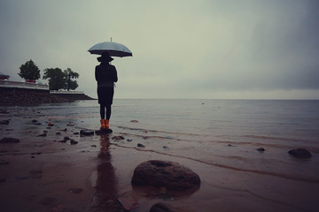 Fototapeta na wymiar woman with an umbrella by the sea wind rain