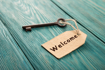 hotel key with welcome tag on the wooden background