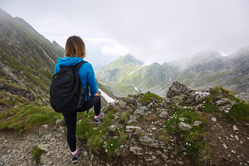 Obraz premium Woman backpacker hiking on a trail