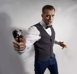 Man with a butterfly on his shirt, with a gun in his hand, gently runs along the white wall