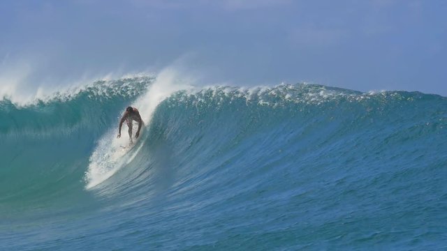 SLOW MOTION: Extreme pro surfer surfing big tube barrel wave