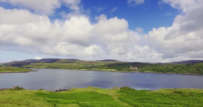 Views of Dunvegan Castle from Uiginish, green summer meadows and the blue water of Loch Dunvegan