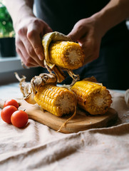 Man hands with roasted corn