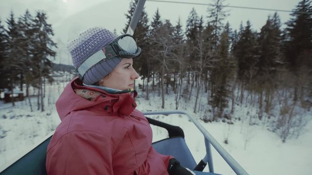 Ski resort, woman ride up on riding lift