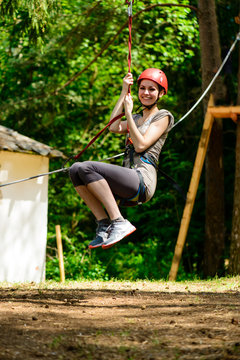 Young woman climbing in adventure climbing high wire park