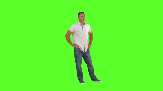 Casual man standing with hands on hips on green screen background