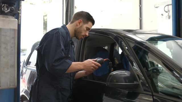 Handsome mechanics overhauling a car in the garage
