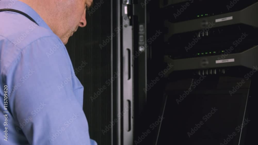 Poster technician using laptop to analyse server