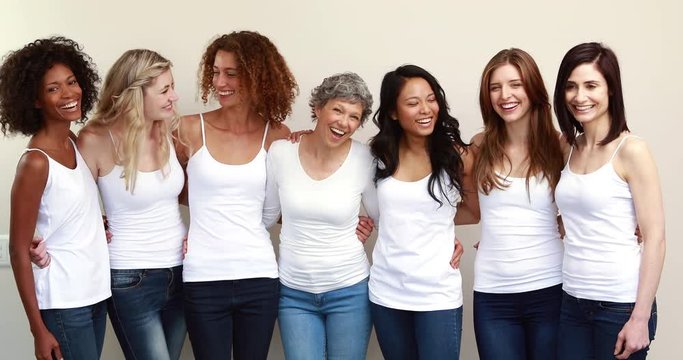 Happy women hugging in a row with white shirts