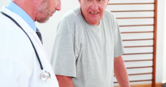 Smiling doctor talking with patient using zimmer frame