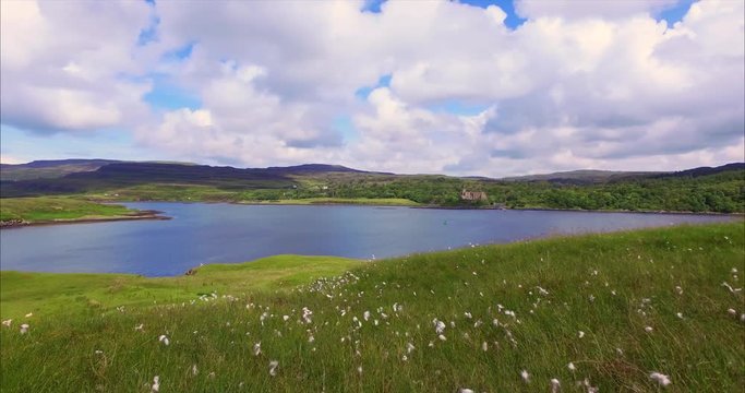 Views of Dunvegan Castle from Uiginish, green summer meadows and the blue water of Loch Dunvegan
