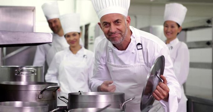 Head chef smelling pot of soup making ok sign