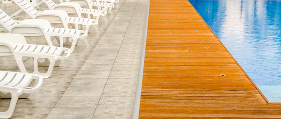Fototapeta na wymiar clean swimming pool and empty resting chair