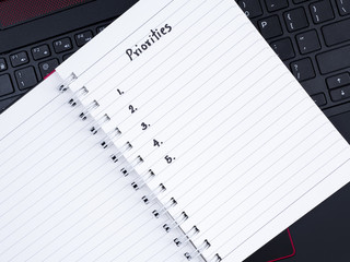 Handwriting Priorities on white notebook with laptop keyboard 1