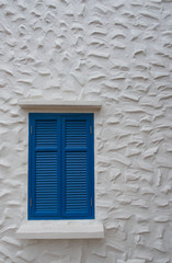 The blue wooden window frame on building stucco wall at home 