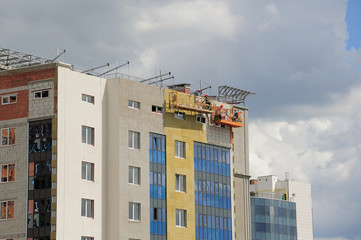 Construction workers thermally insulating house facadel.