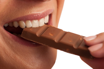 Beautiful young woman eats chocolate isolated over white backgro