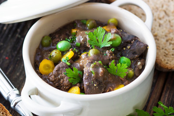 Chicken liver in  sauce with vegetable on wooden background