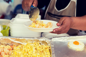 close up of hands with wok at street market