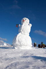 Big snowman on sky background