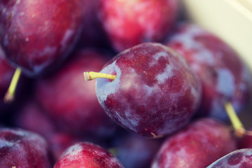 close up of satsuma plums in box at street market