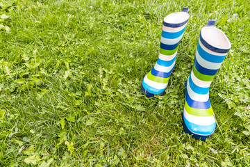 Rubber boots with stripes on a gras background © pirke