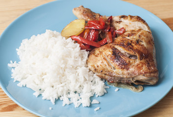 Roasted chicken leg served with white rice.