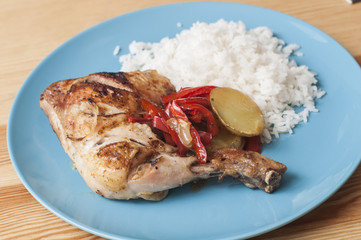 Roasted chicken leg served with white rice.