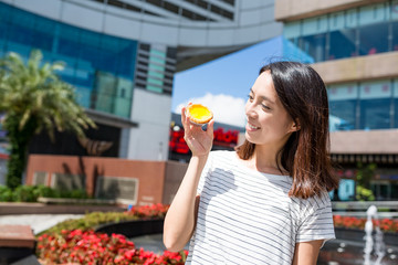 Woman enjoy the egg tart in Hong Kong