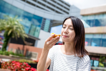 Woman enjoy egg tart at outdoor
