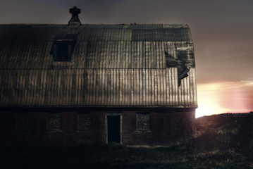 Fototapeta premium Old barn on a farm, sunrise in background.