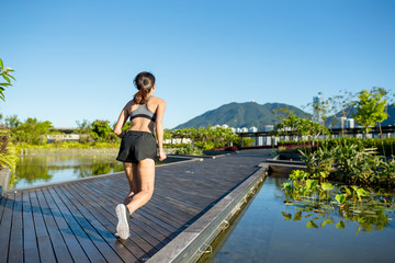 Woman running in a boardwalk