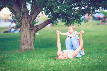 Happy family of three lying in the grass . Warm effect added.