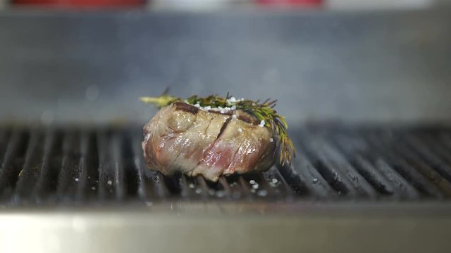 Beef steak is grilling at restaurant kitchen