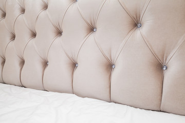 Soft pink headboard and white bedding