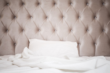 Pink headboard, white bedding sheet and pillow