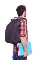 Back view of a male student standing with backpack and notebooks