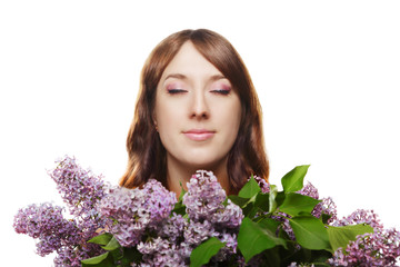 Beautiful woman enjoying breathing in flavor of lilac flowers