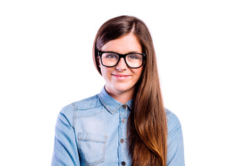 Girl in denim shirt and black eyeglasses, studio shot