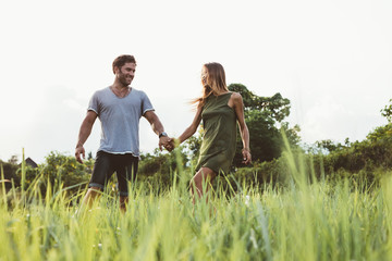 Young couple walking in field of tall grass © Jacob Lund